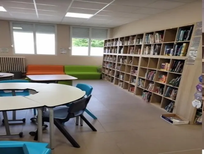 Vue intérieure du Centre de Documentation et d'Information (CDI) avec ses rayonnages de livres et tables de travail.